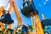 Three yellow excavators lined up on a sunny day