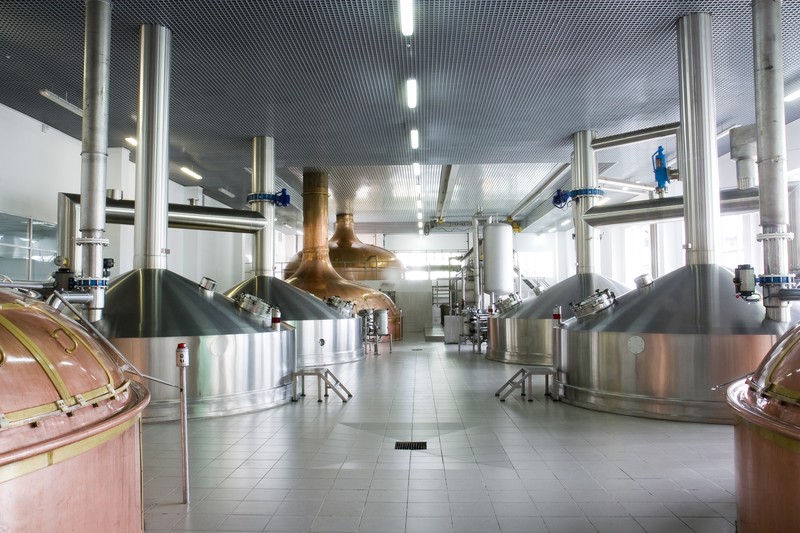 The inside of a brewery with large metal containers